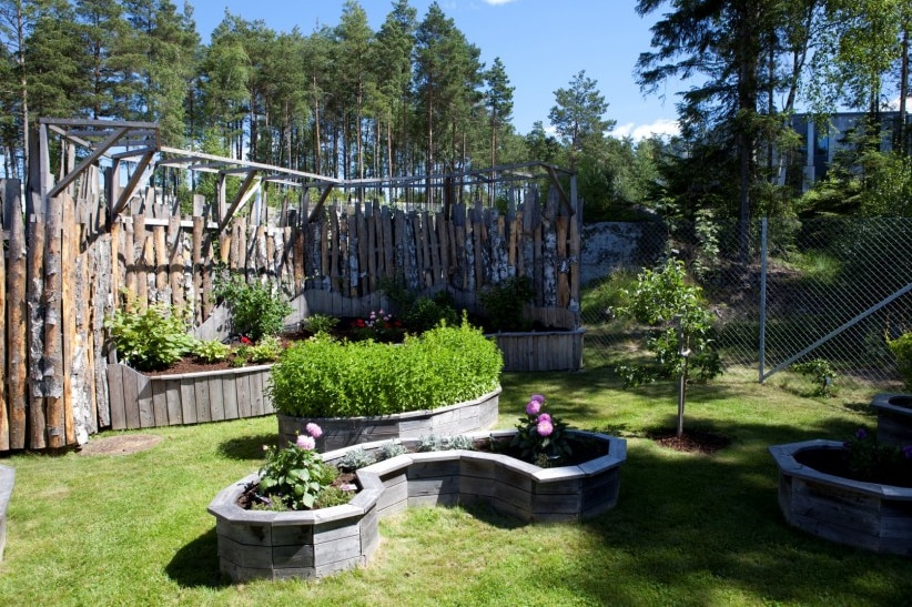 A tranquil green garden with plants and tall trees in the prison facility.