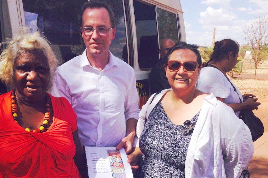 Martu elder, Dawn Oates, Greens MP David Shoebridge and Suellyn Tighe pictured next to a bus in Newman.
