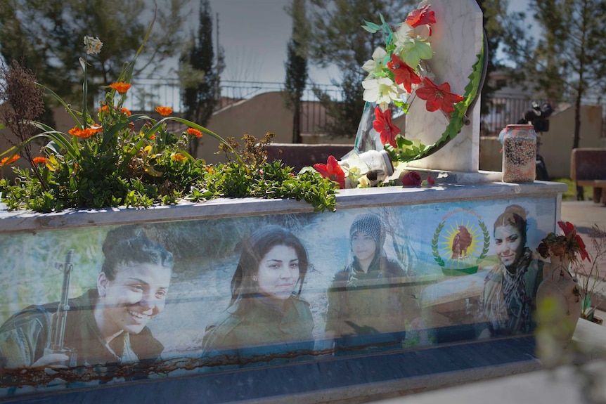 Headstones with photos of the women who fought against Islamic State.