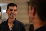 Man looking in a mirror and smiling.
