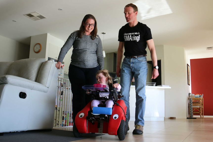 Stephanie Nave is in her motorised chair while parents Amanda and Mark watch on.