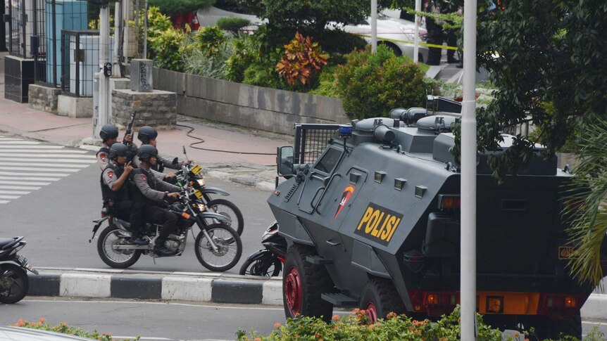 Indonesian police on bikes with armoured vehicle.