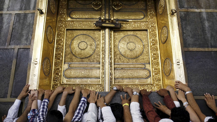 Pilgrims touch the holy Kaaba at the Grand Mosque