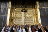 Pilgrims touch the holy Kaaba at the Grand Mosque