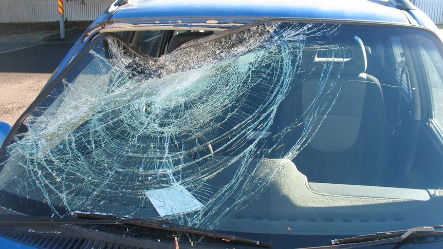 A windscreen which has been damaged after a large rock was thrown at it