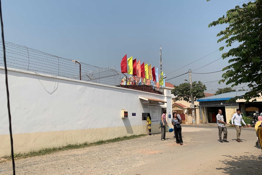 A prison wall decorated with colourful flags in Cambodia.