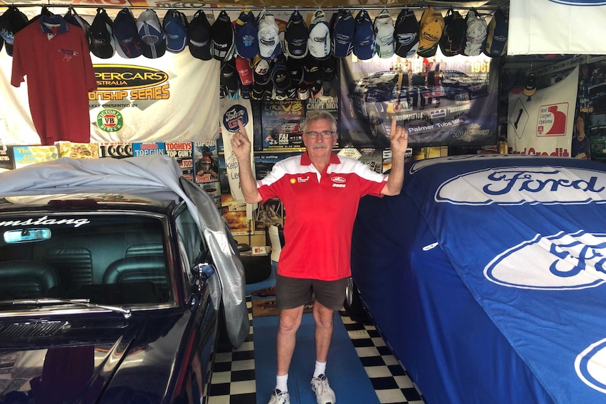 A man points to his Supercars memorabilia.