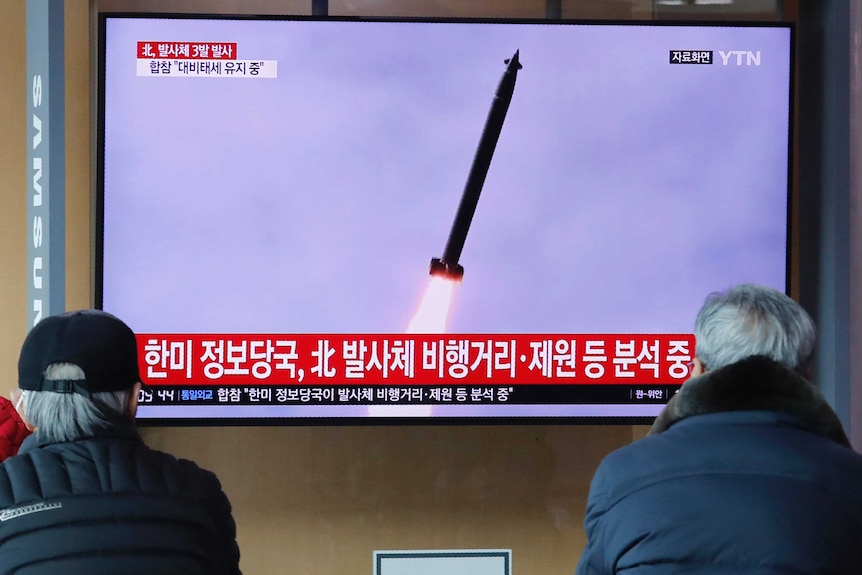 People watch a TV showing of North Korea's missile launch during a news program