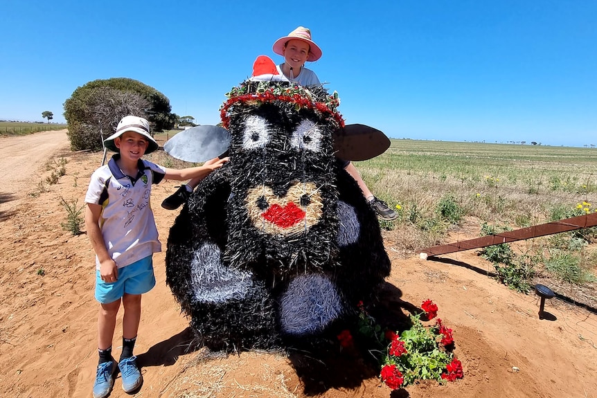 hay bales that have been turned in to a black cow for a christmas display