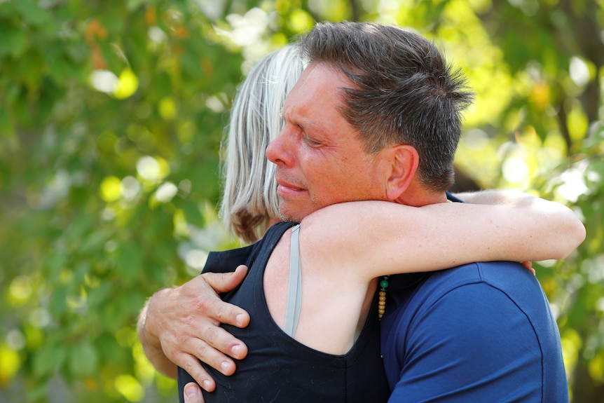 Don Damond hugs a neighbour after reading a statement about his slain fiance in July, 2017. 