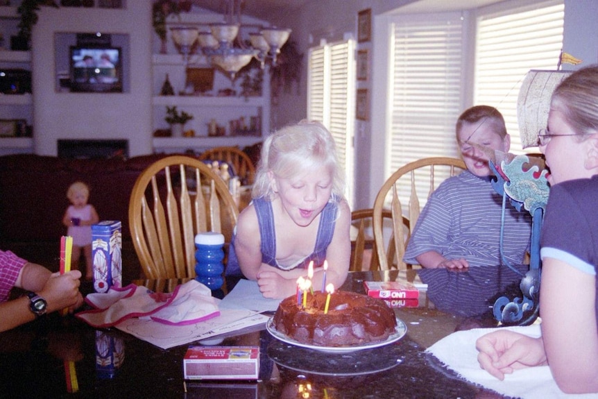 Chloe Tomlinson, who suffers from a rare brain disease, blowing out candles.