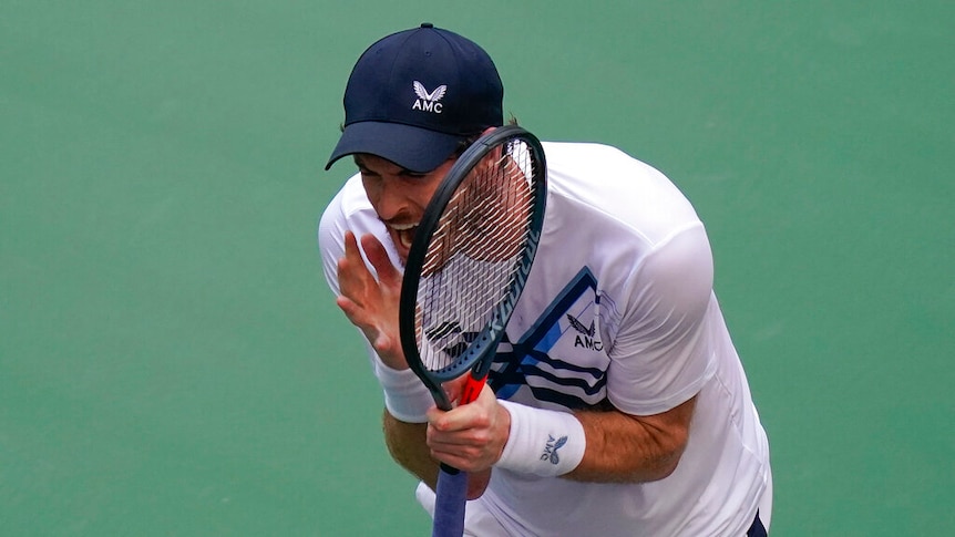 Andy Murray yells and brandishes his racquet.