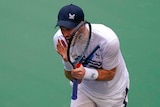 Andy Murray yells and brandishes his racquet.