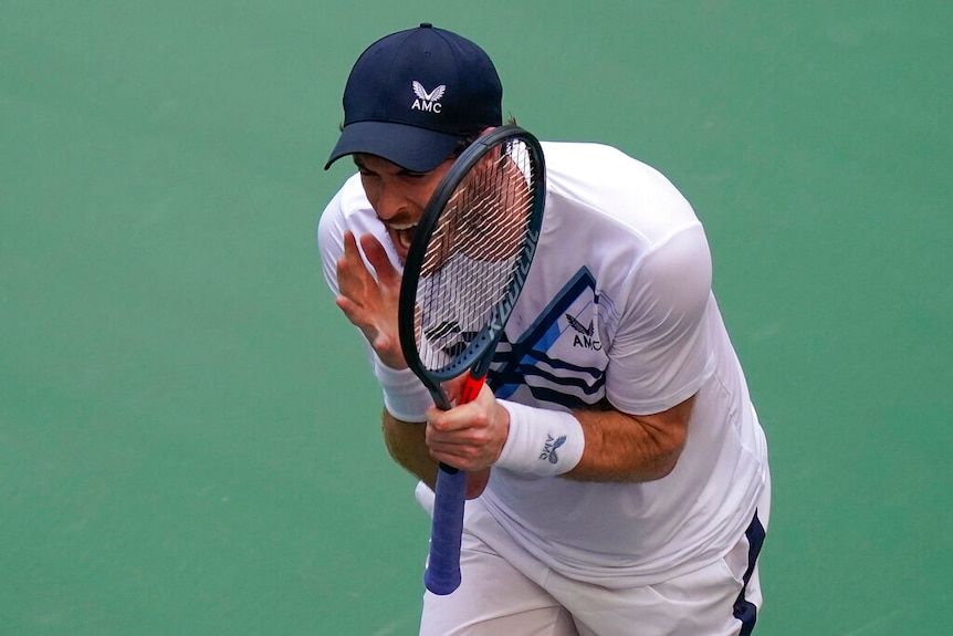 Andy Murray yells and brandishes his racquet.