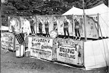A line of tent boxers stand outside Harry Paulsen's Touring Stadium in this black and white photo from 1946.