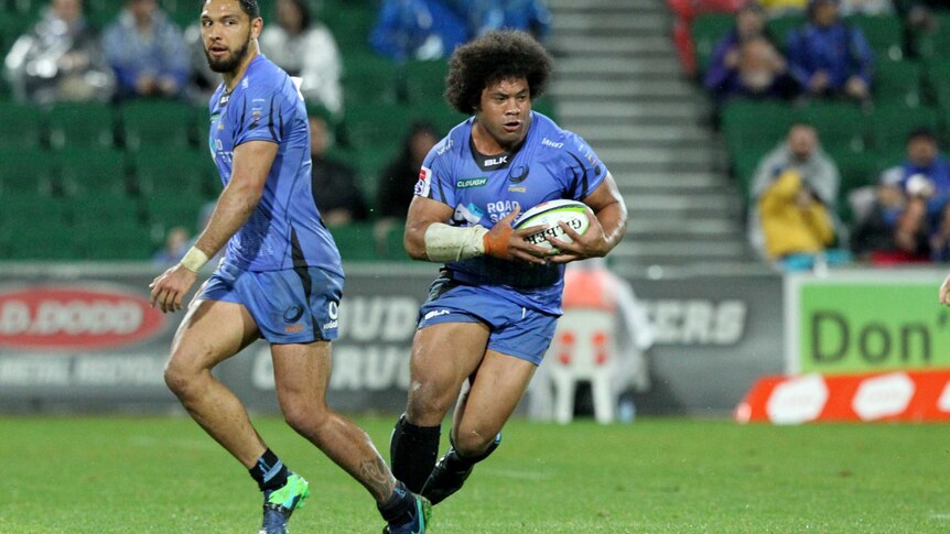 Tatafu Polota-Nau carries a rugby ball while playing for the Western Force, with a teammate to his right.
