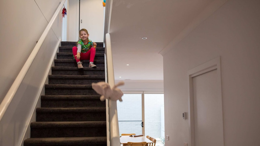 Six-year-old Scarlet plays on the stairs before school.