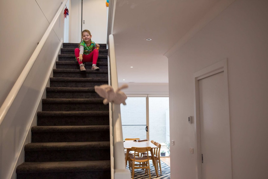 Six-year-old Scarlet plays on the stairs before school.