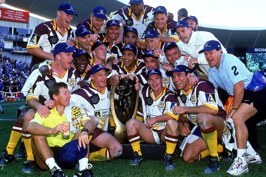 A group of rugby league players celebrate after winning a match
