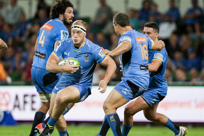 Un joueur de rugby court avec le ballon à travers une mer de coéquipiers