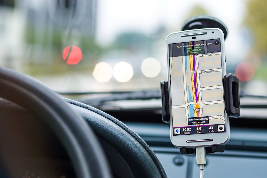 Un écran de téléphone s'ouvre sur l'application de navigation dans la voiture.