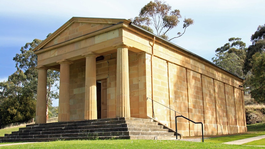 A sandstone building with columns in a Australian bush setting