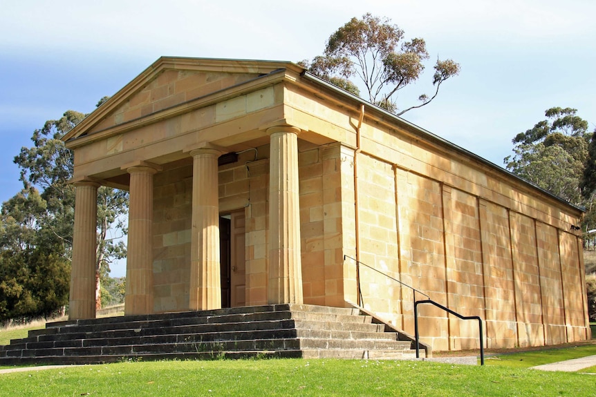 A sandstone building with columns in a Australian bush setting