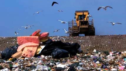 A tractor plows over rubbish dumped at a Brisbane landfill site