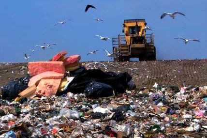 A tractor plows over rubbish dumped at a Brisbane landfill site