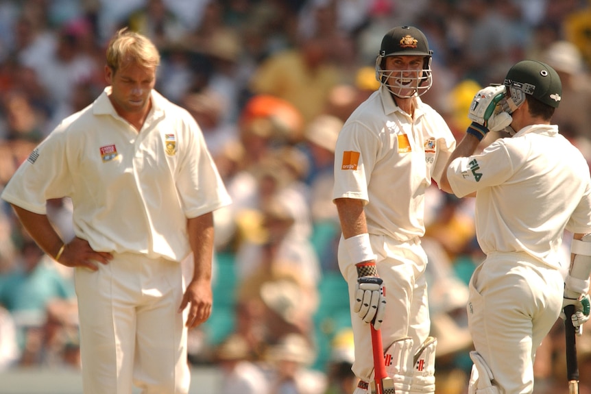 Jacques Kallis looks down as Matthew Hayden and Justin Langer talk wearing batting gear