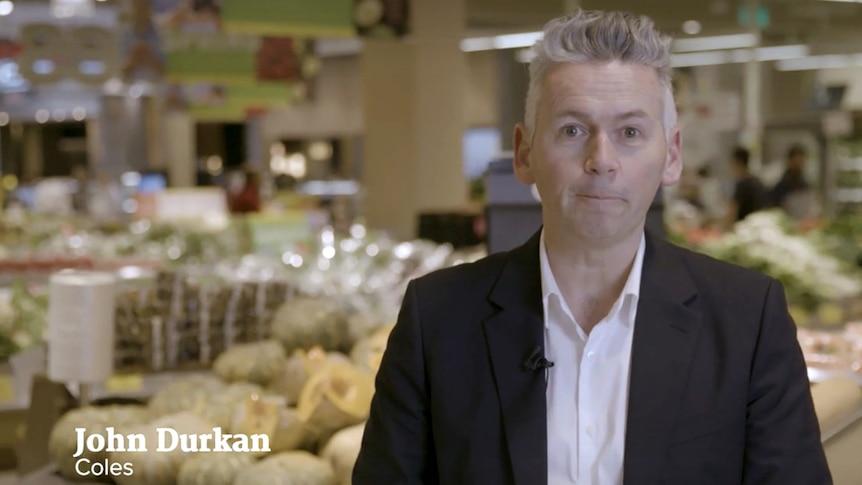 Coles, Managing Director standing in front of produce talking to camera for video appearance