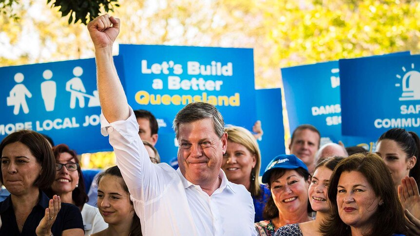 Queensland LNP leader Tim Nicholls raises his fist in air with defiant look on face
