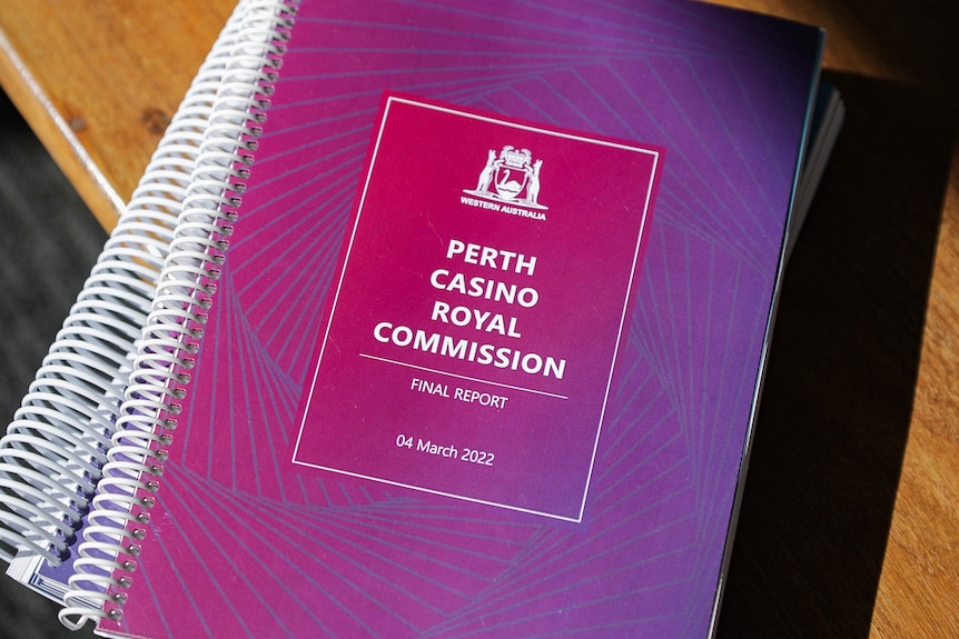Two bound books with purple covers stacked on top of each other, with the words 'Perth Casino Royal Commission' on the front.