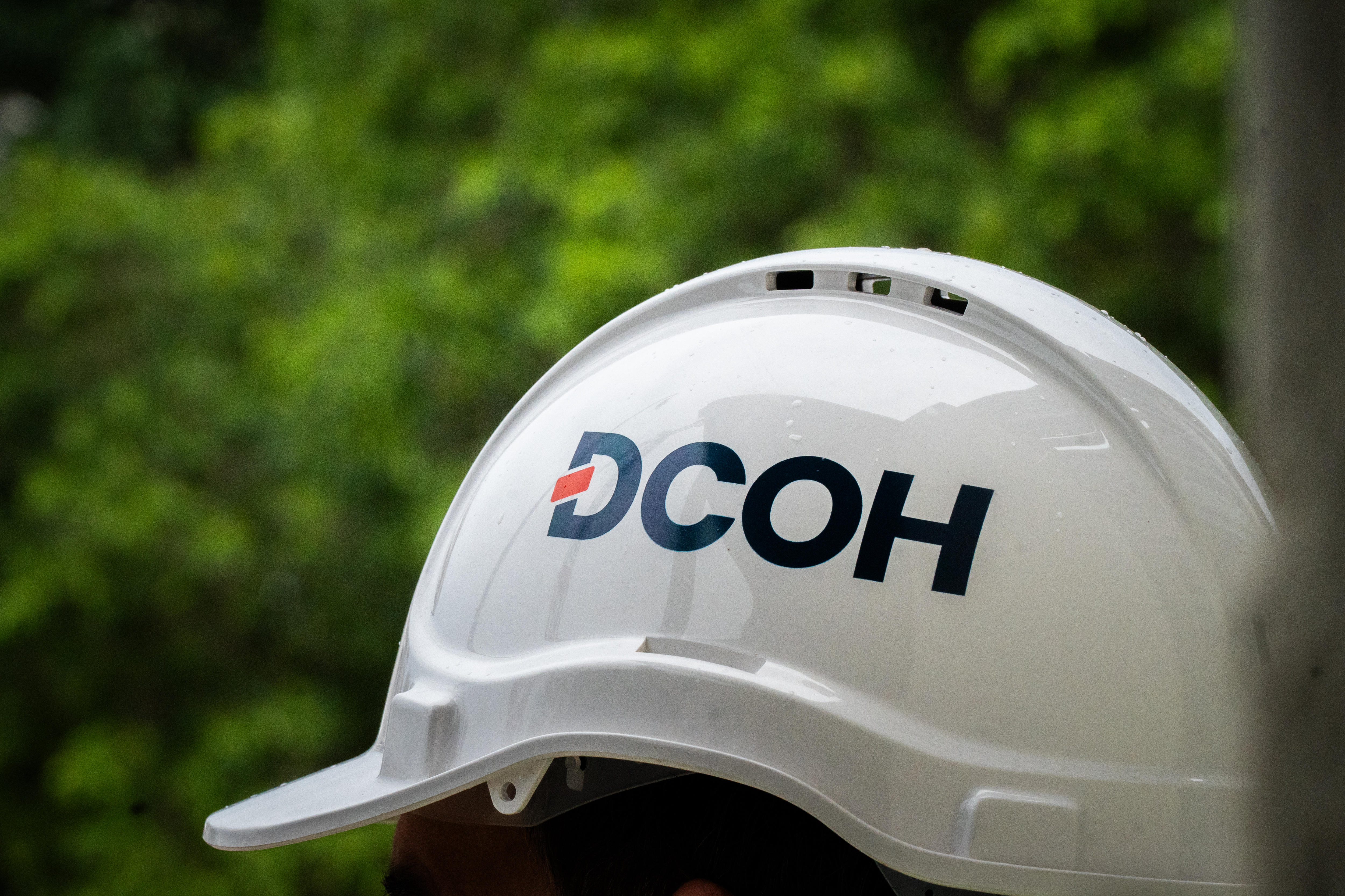 Um capacete branco com o logotipo DCOH impresso na lateral.