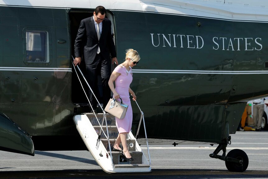 Steve Mnuchin and his wife Louise Linton step off US government plane.