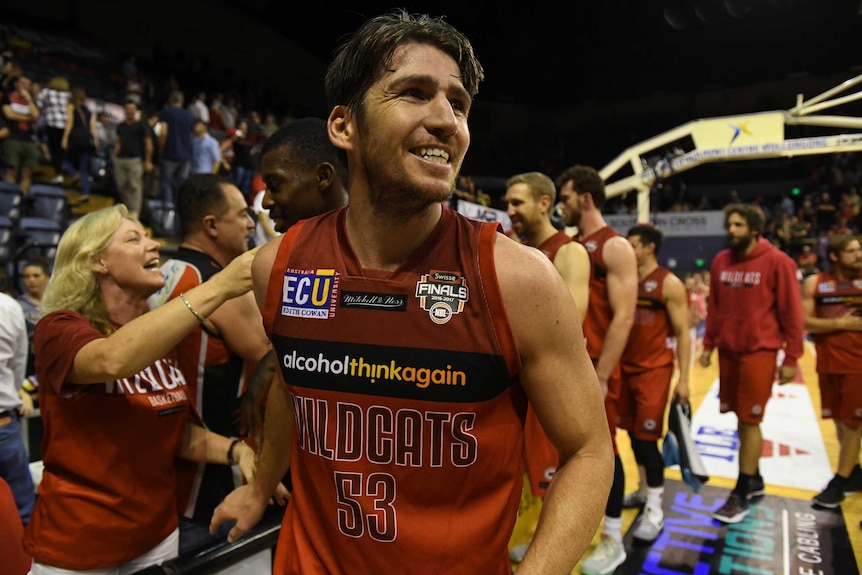 Damian Martin celebrates with Wildcats fans after the win over the Hawks in game two.