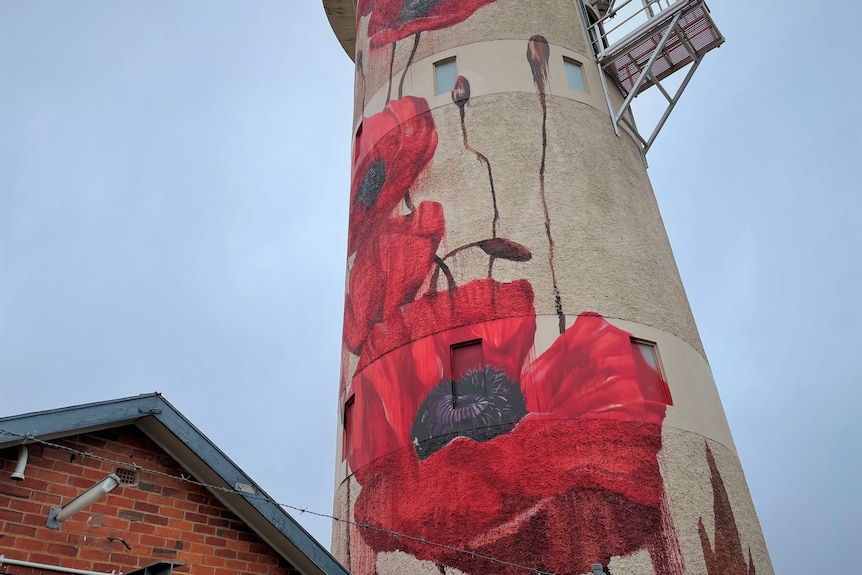 Water tower with poppies painted on it