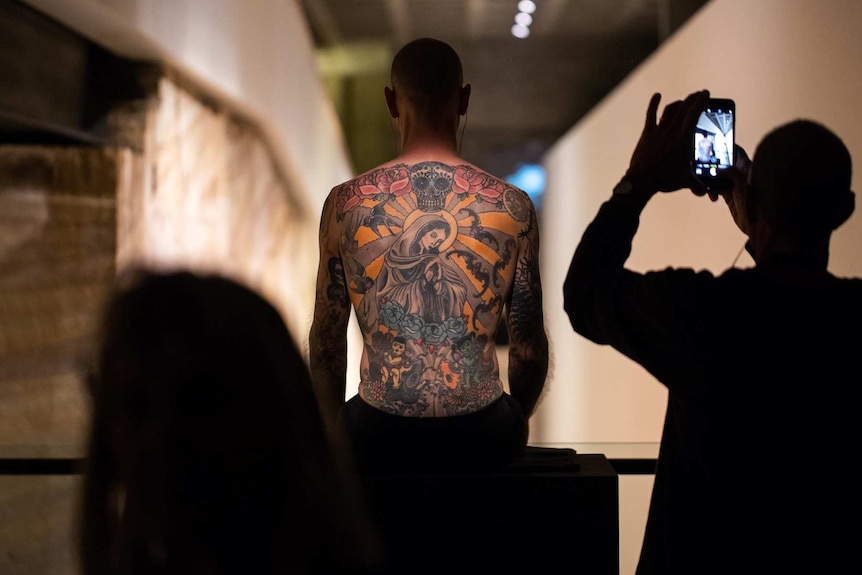 Tim, the tattooed man, sits as part of the artworks at MONA, Berriedale, Hobart.