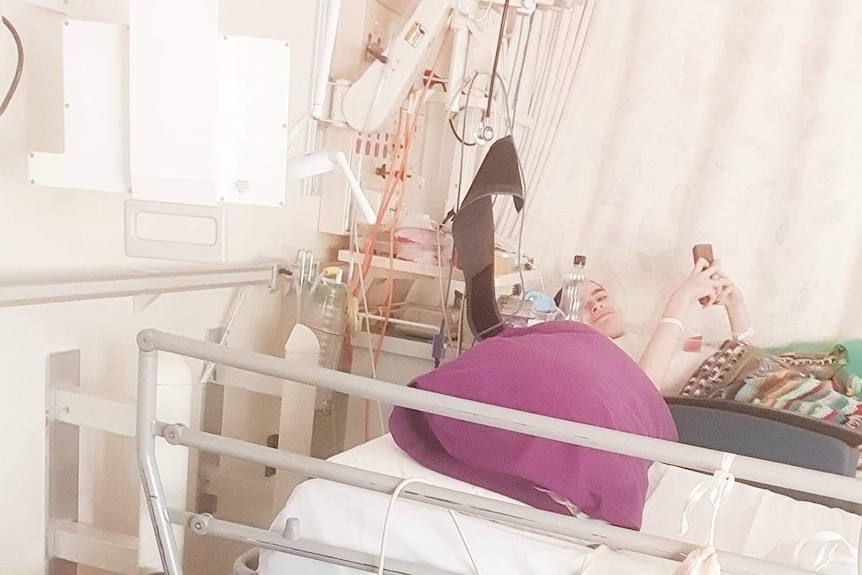 Mother and her sick son lie side by side in hospital beds.
