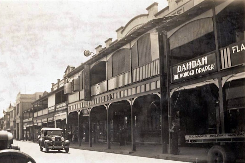 A black-and-white image showing shops on the main street of a regional town in the 1930s.