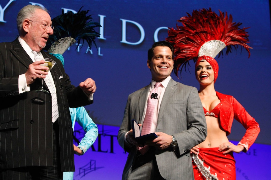 Anthony Scaramucci smiles on stage with performers during a conference for Skybridge Capital