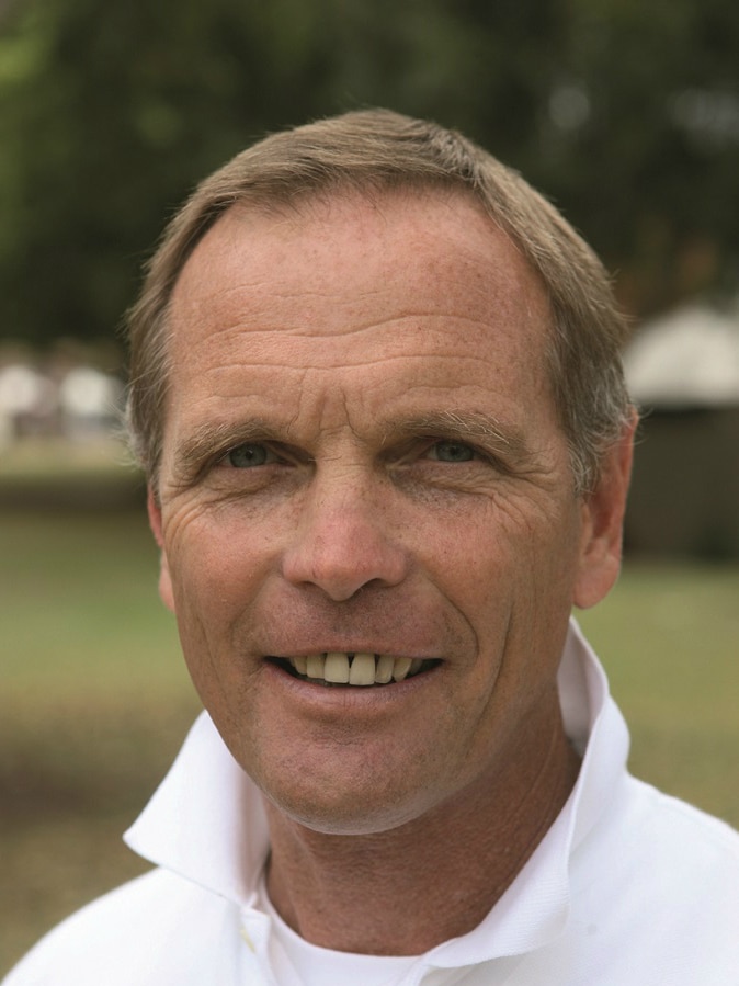 Portrait photo of Garth Prowd who is smiling, looking at the camera, tanned skin and short blonde hair.