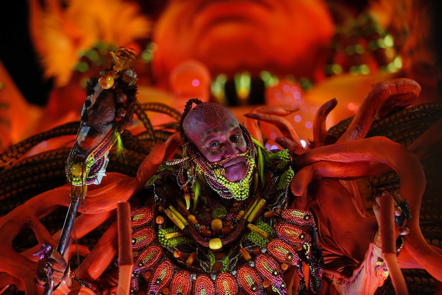 A performer from the Salgueiro samba school parades during Carnival celebrations with a black face makeup tribal dress.