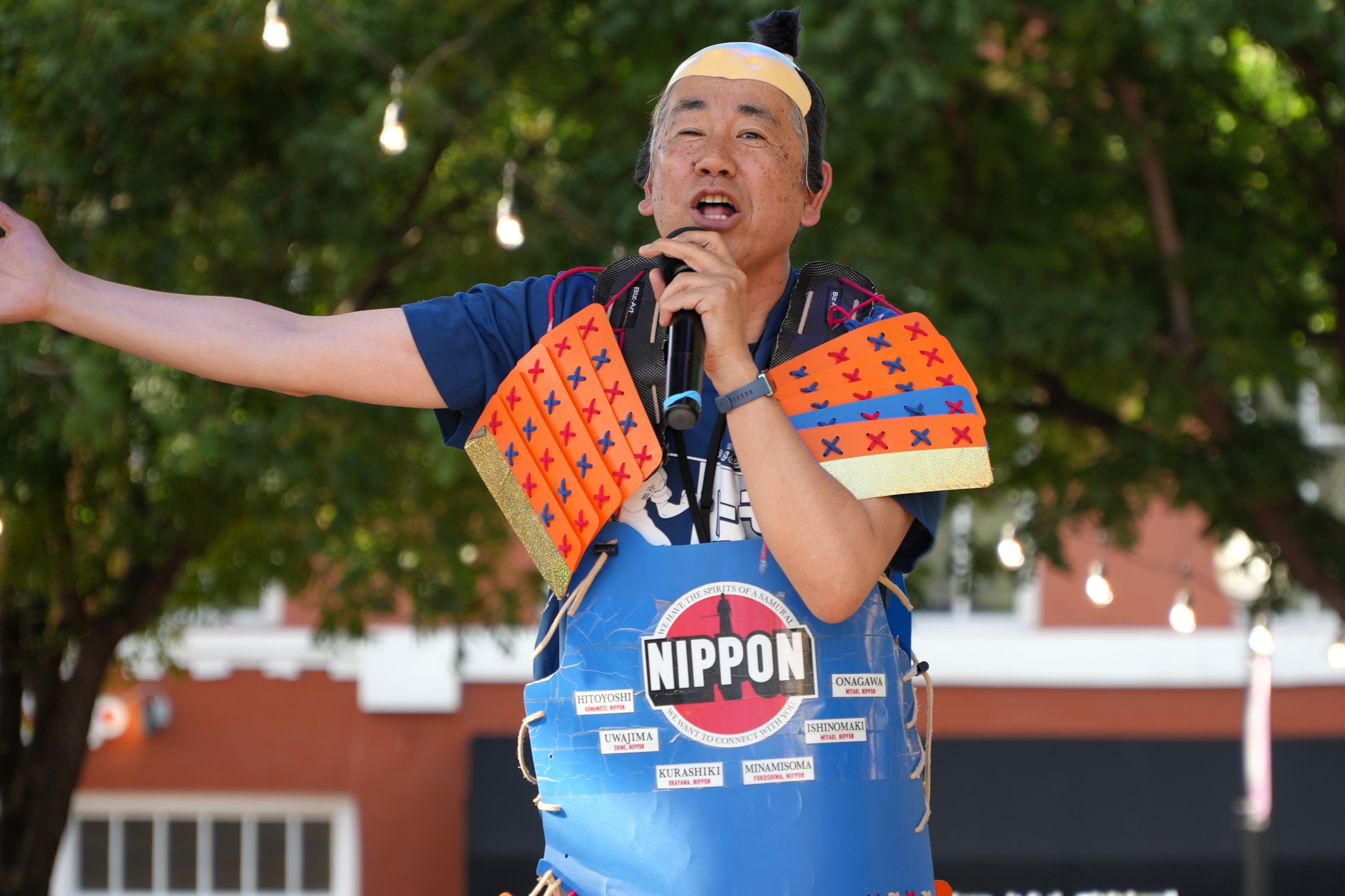 A Japanese man with cardboard orange and blue 'armour'.