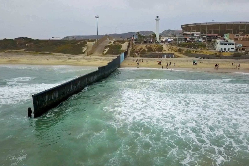 The fence separating the US from Mexico juts into the Pacific Ocean.