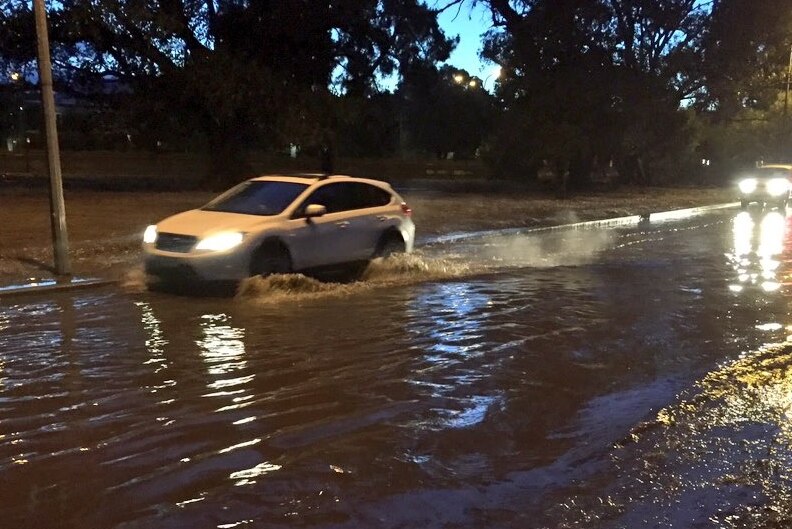 Car drives through water after heavy rain