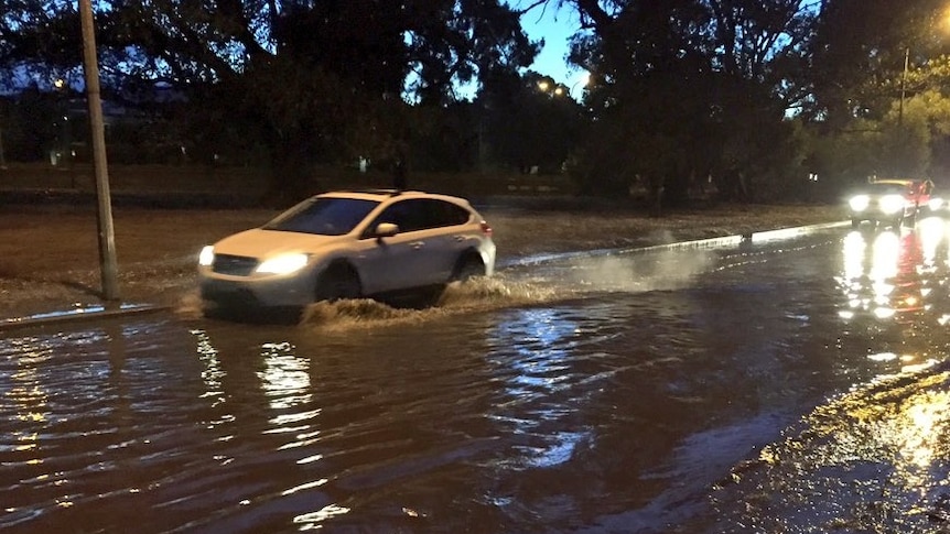 Car drives through water after heavy rain
