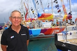 Ross Ham pictured in front of sailing yachts in Airlie Beach