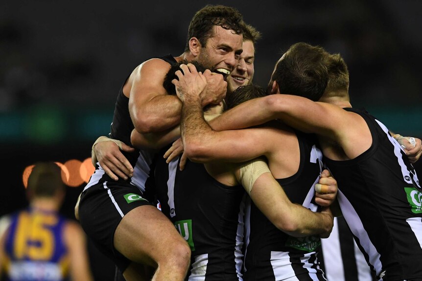 Collingwood players celebrate as Alex Fasolo scores in the final moments against West Coast.
