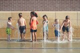 Kids playing in water fountains